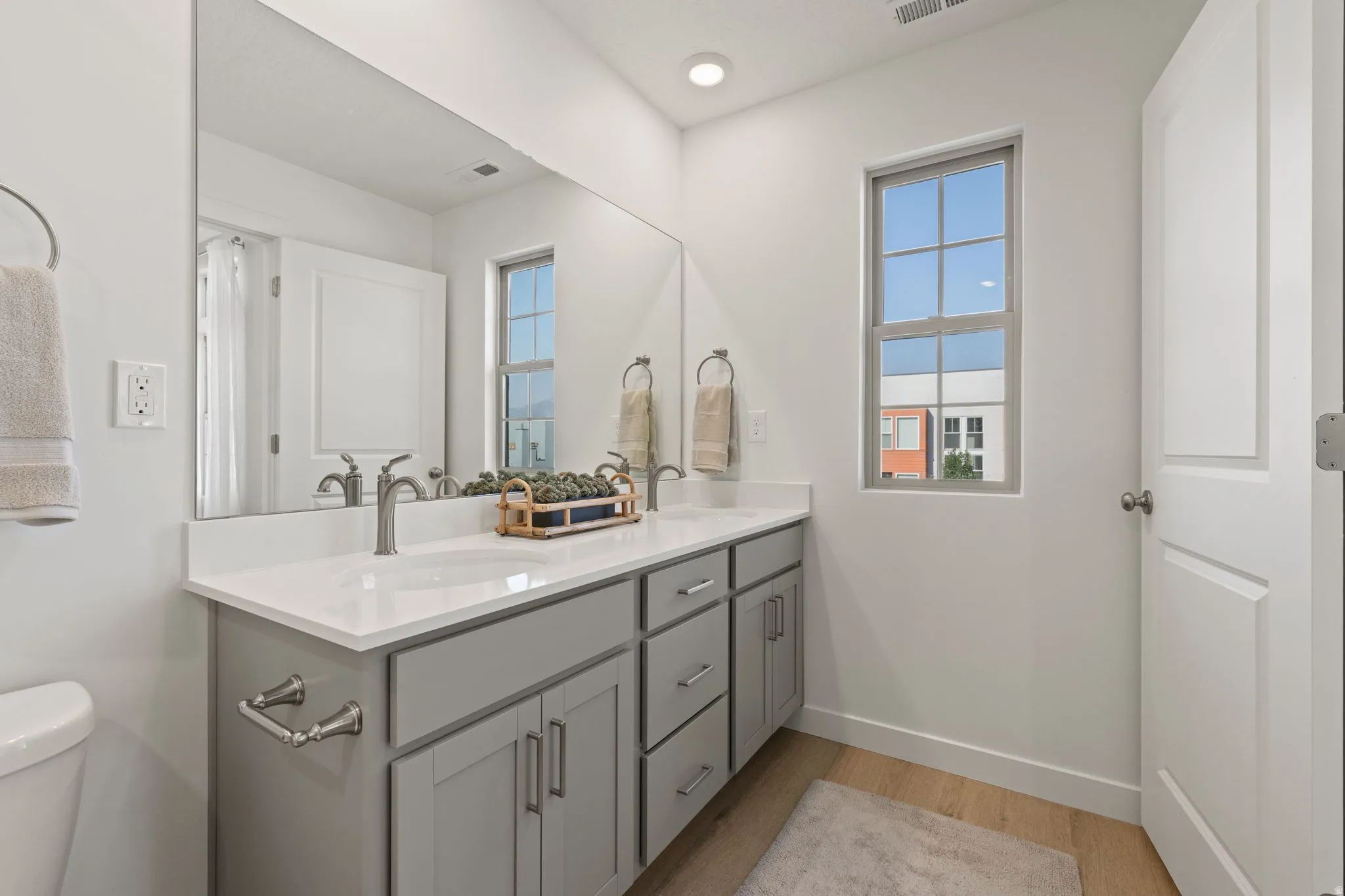 Dual vanity with light gray cabinetry, brushed nickel hardware, and white countertops