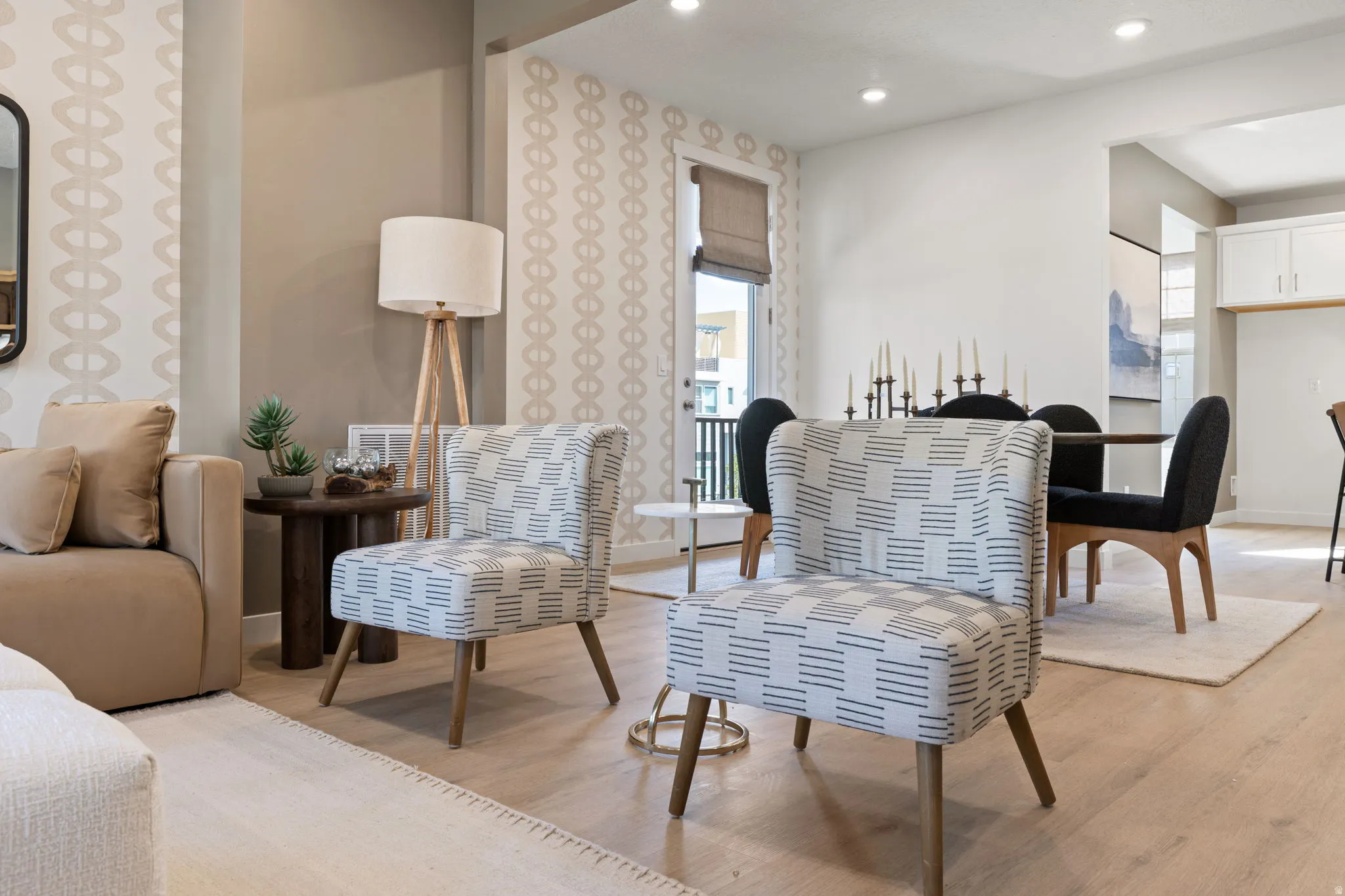 Bright living spaces showcase light wood-finish flooring, geometric patterned wallcovering, and recessed ceiling lighting