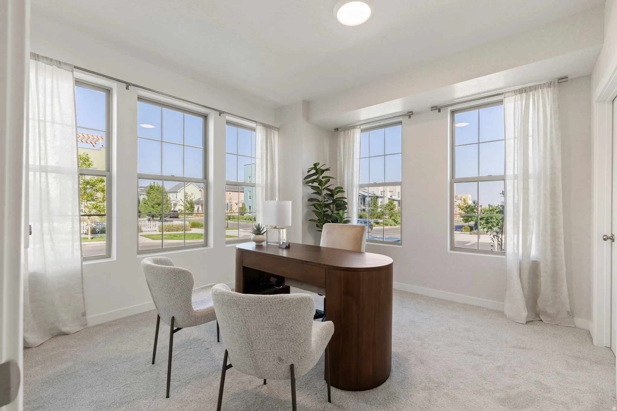 Recessed ceiling lighting, white walls, light-toned carpet, and multiple grid-pattern windows