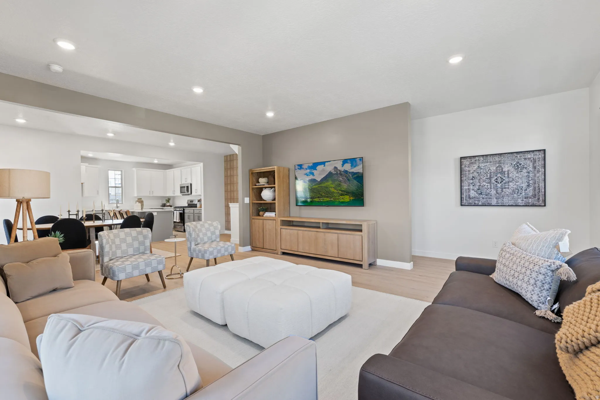 Open-concept living space featuring recessed lighting, light wood-finish flooring, and a neutral color palette