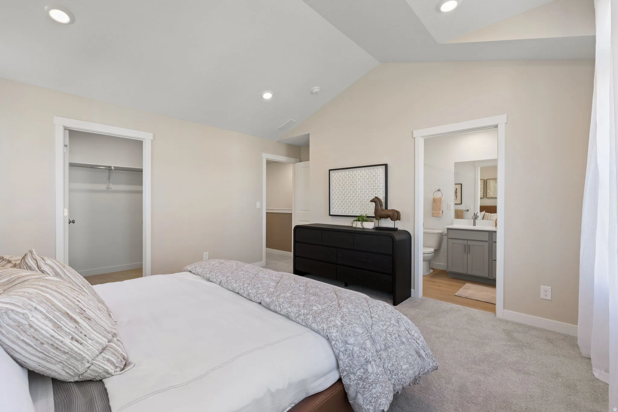 Vaulted ceiling with recessed lighting, carpet flooring, and white trim
