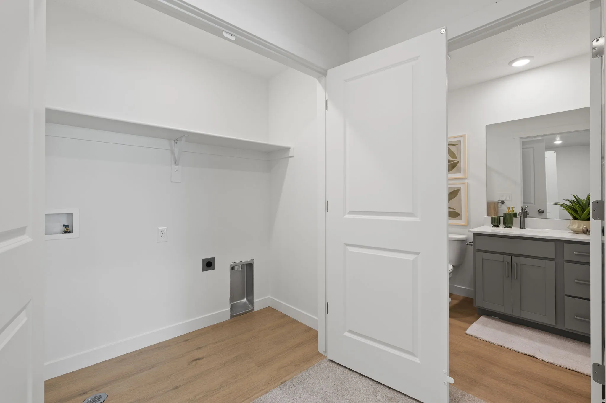 Utility area with wood-finish flooring and integrated shelving