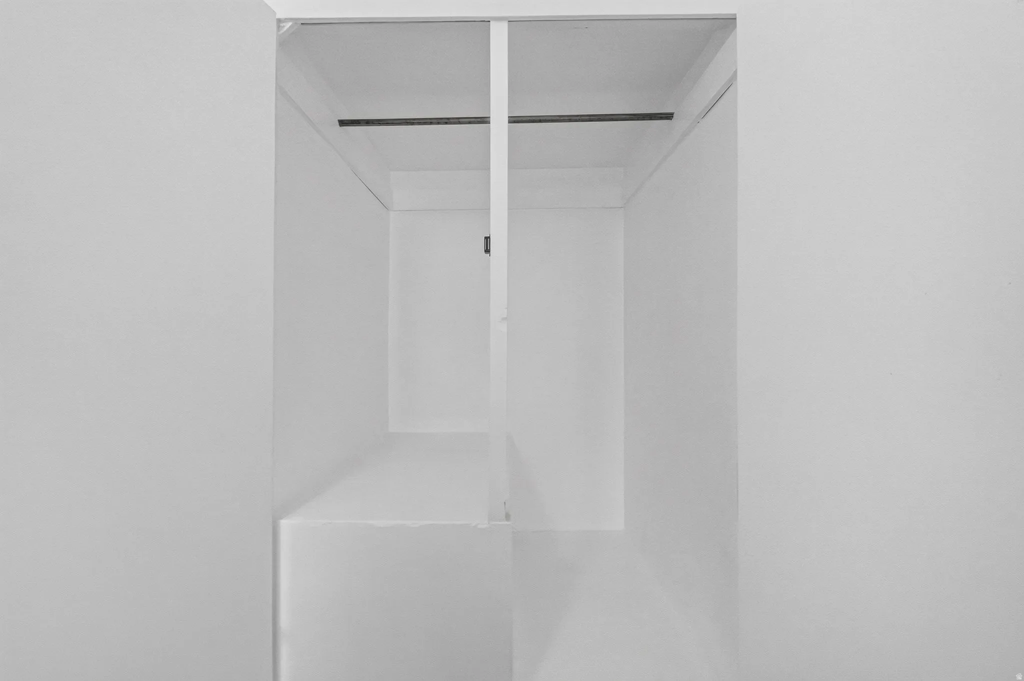Built-in closet featuring an integrated hanging rod and interior shelving