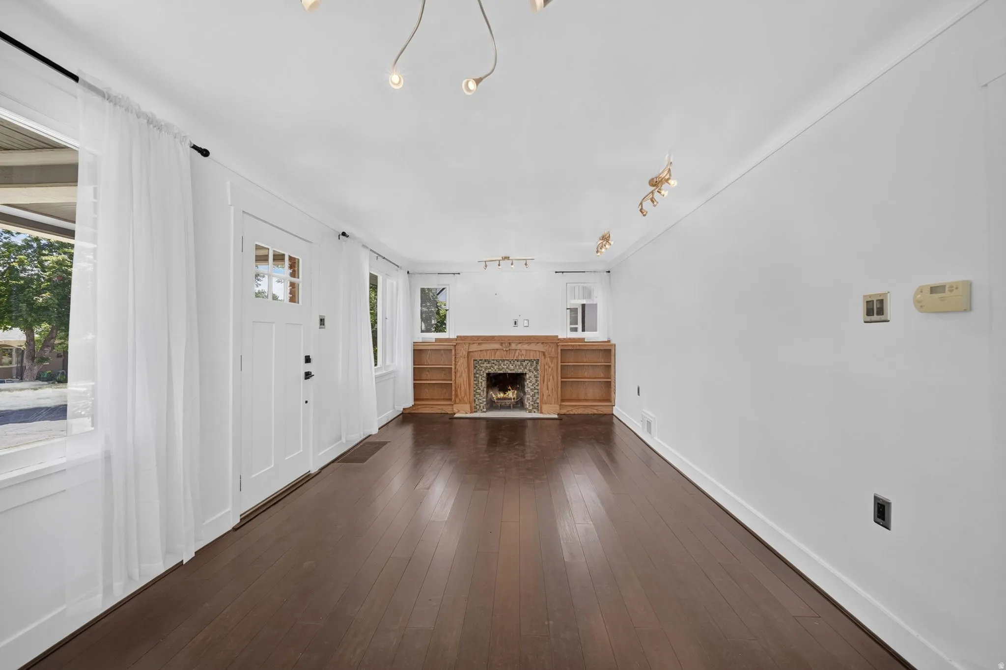 Dark wood-finish flooring with crisp white walls