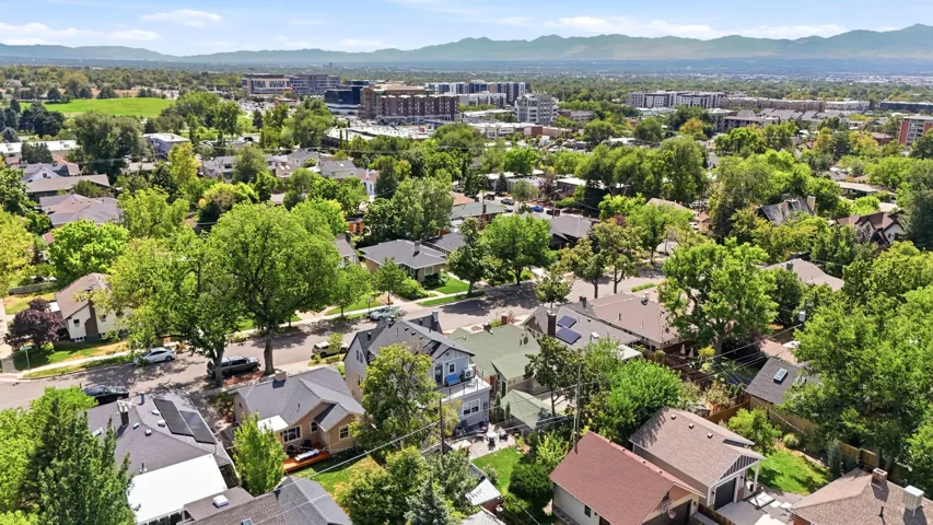Expansive residential neighborhood with mature trees, established homes, and distant mountain backdrop