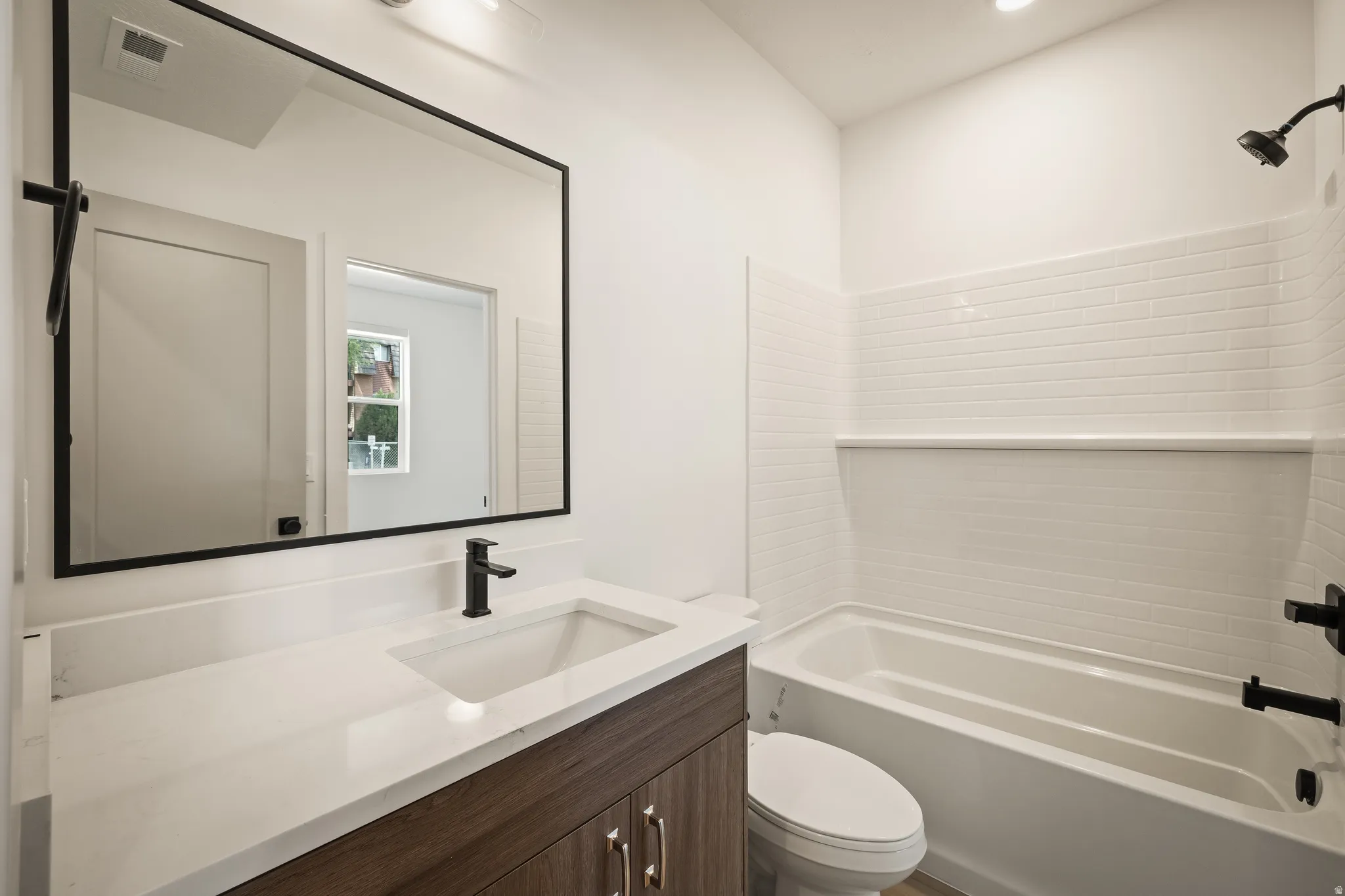 Wood-finish vanity with a white countertop and undermount sink