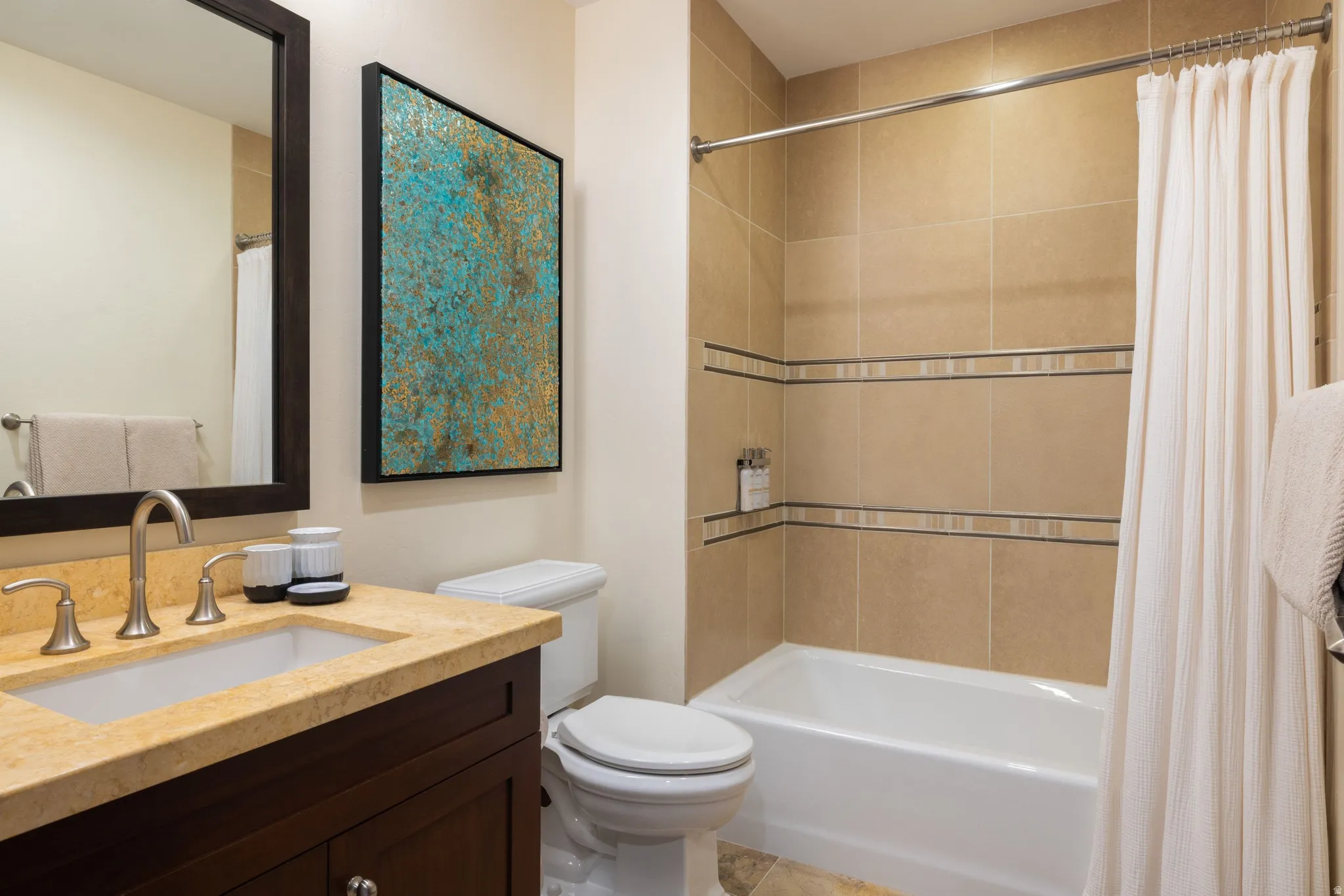 Bathroom featuring a dark wood vanity with a stone-finish countertop, undermount sink, and brushed nickel fixtures