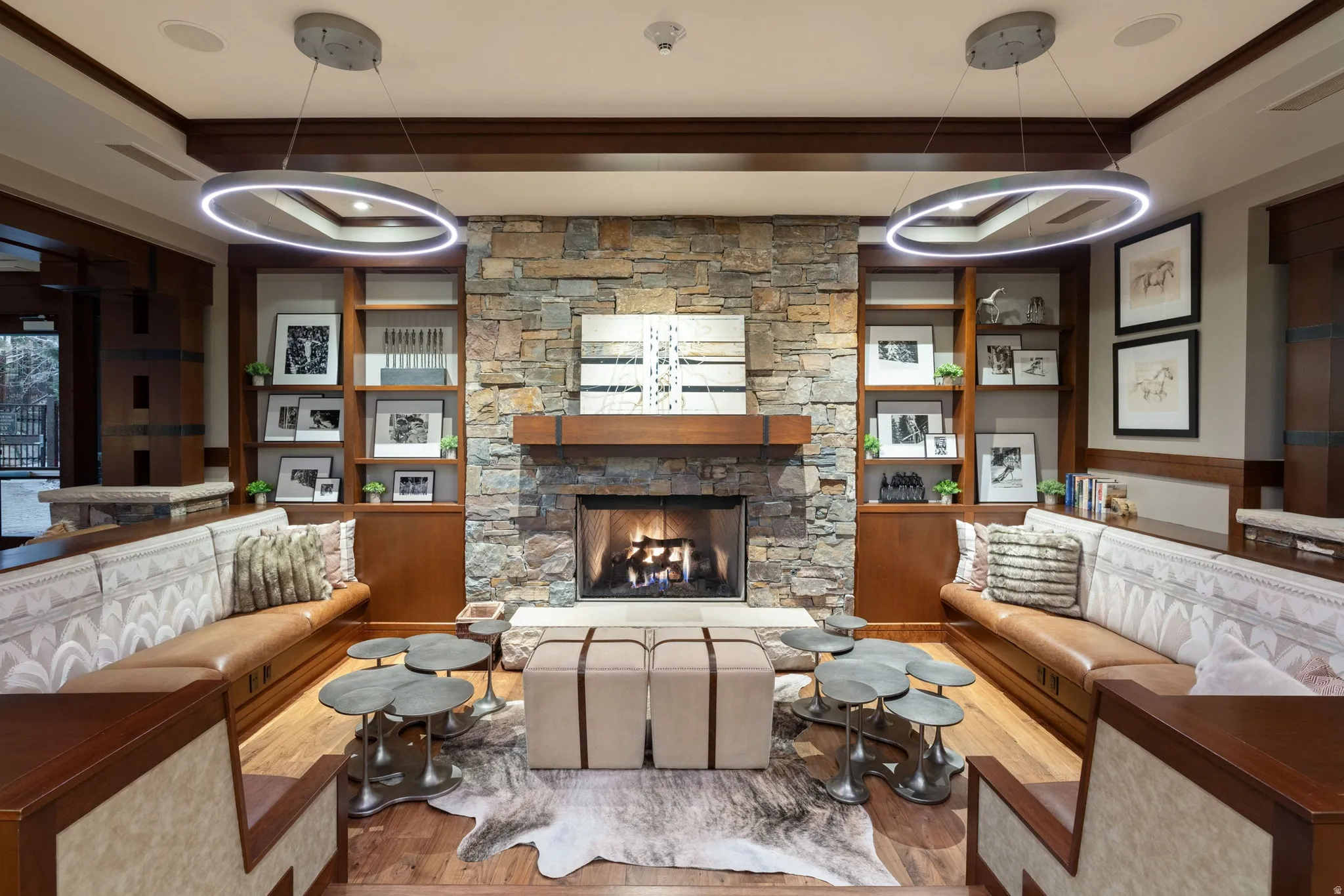 Stone-clad fireplace with a wood mantel, flanked by built-in shelving and cabinetry