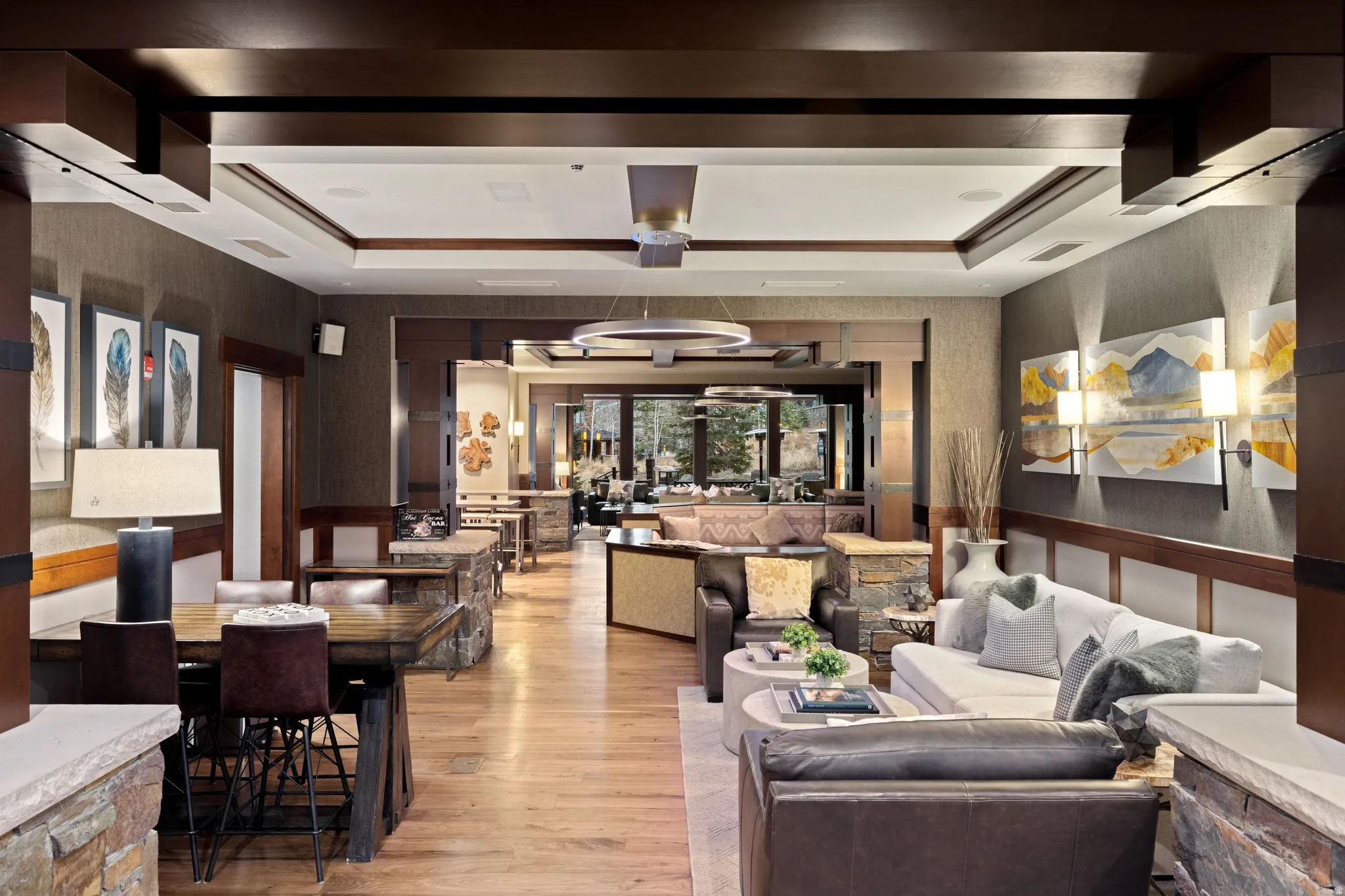 Expansive interior featuring wood-finish flooring, stone accents, and detailed ceiling beams