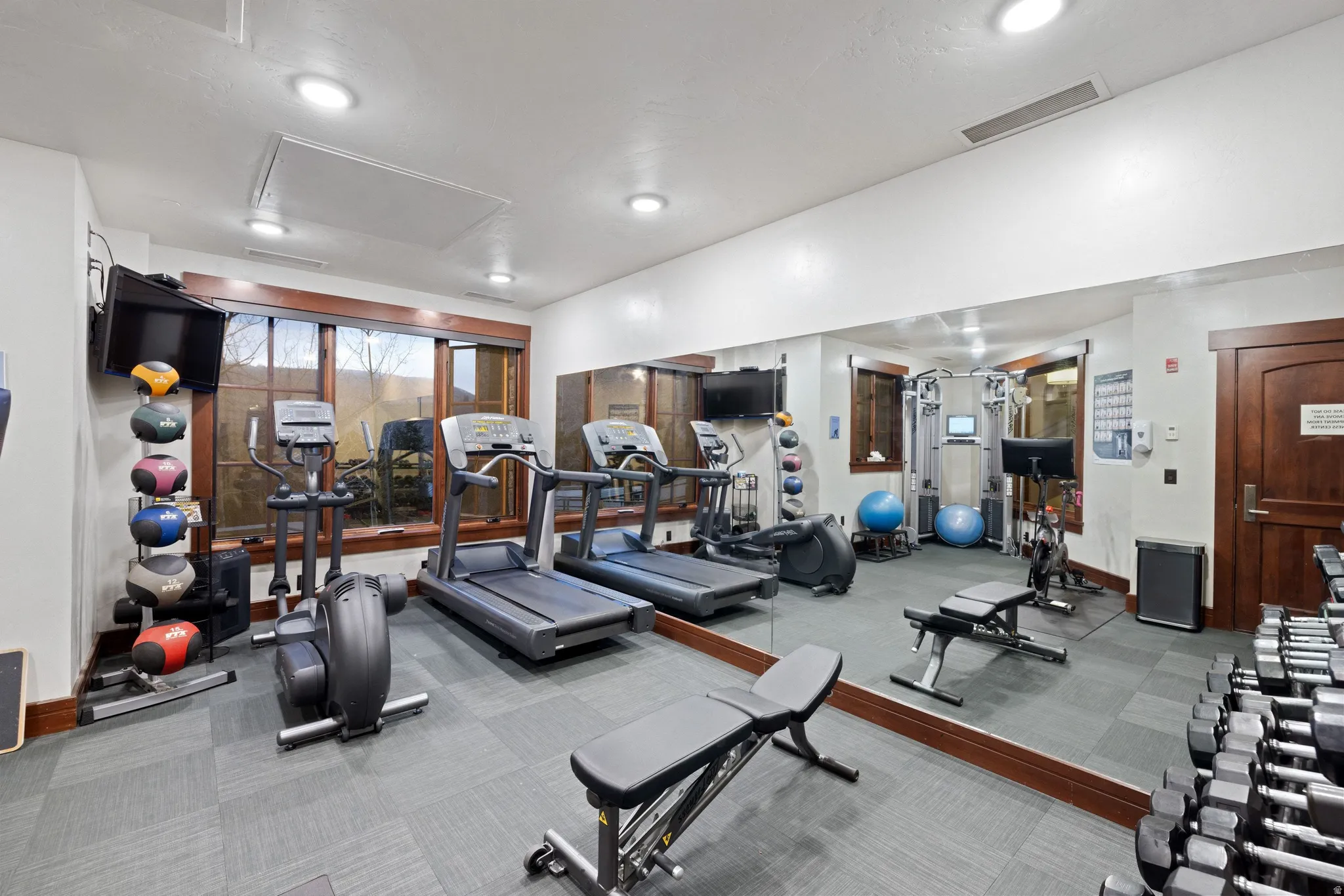 Dedicated fitness space featuring patterned carpet flooring and recessed lighting