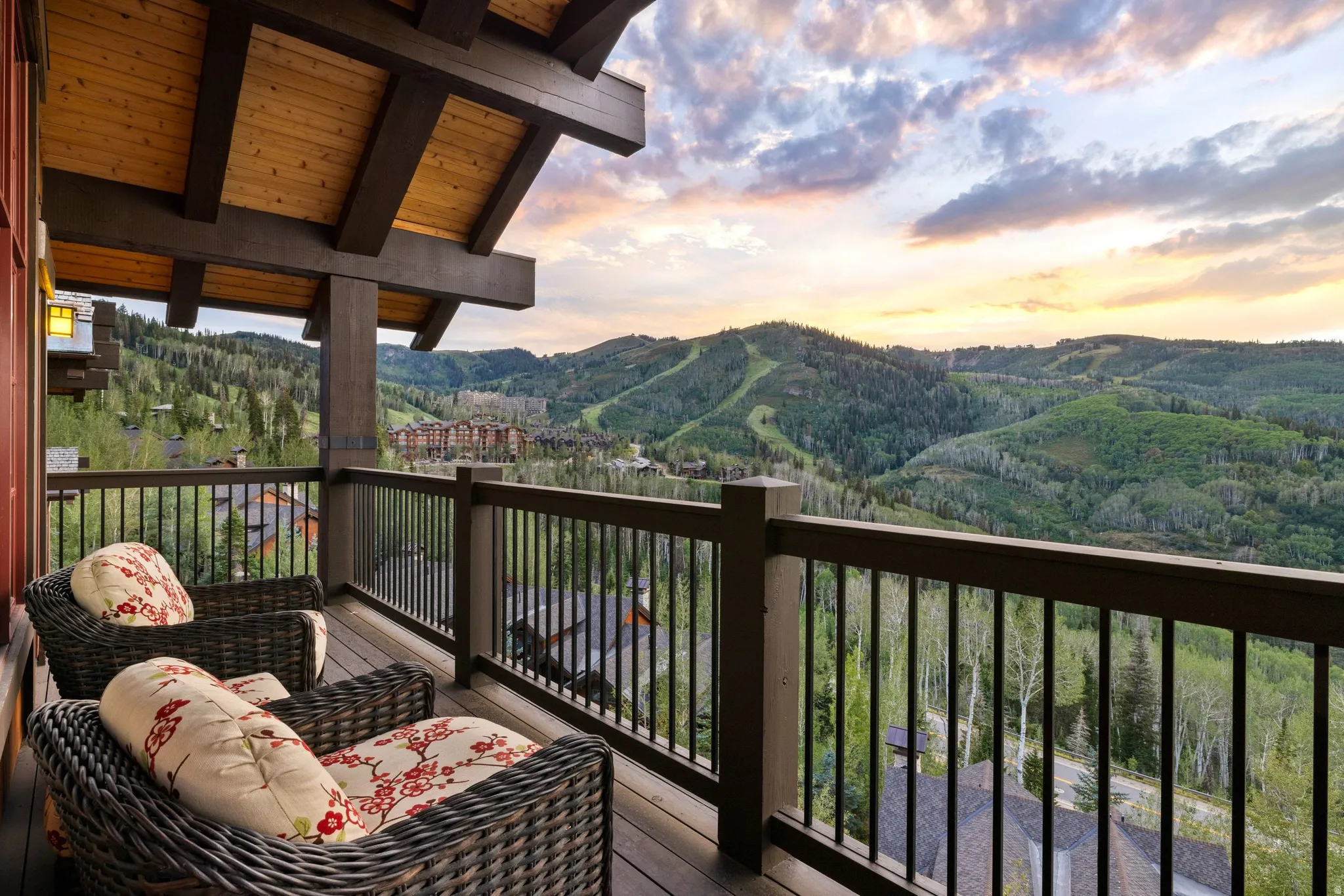 Expansive outdoor balcony with wood decking and dark wood railing