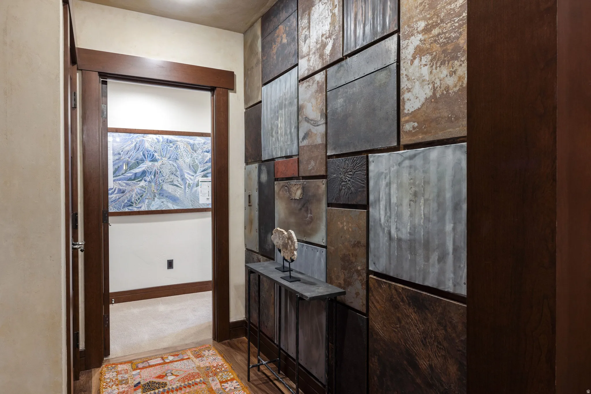 Custom wall paneling, wood-finish door frames, built-in console table, light-toned wall finish, and wood-finish flooring