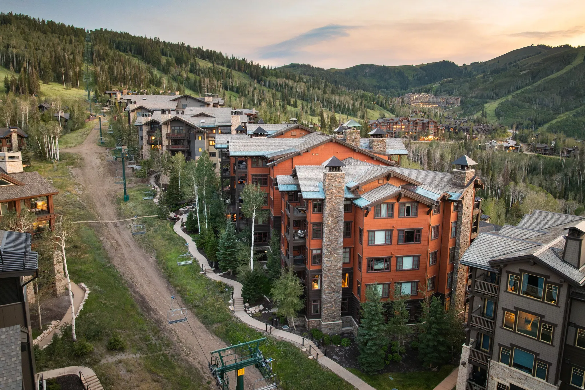 Multiple residential buildings featuring wood siding and stone-clad chimneys