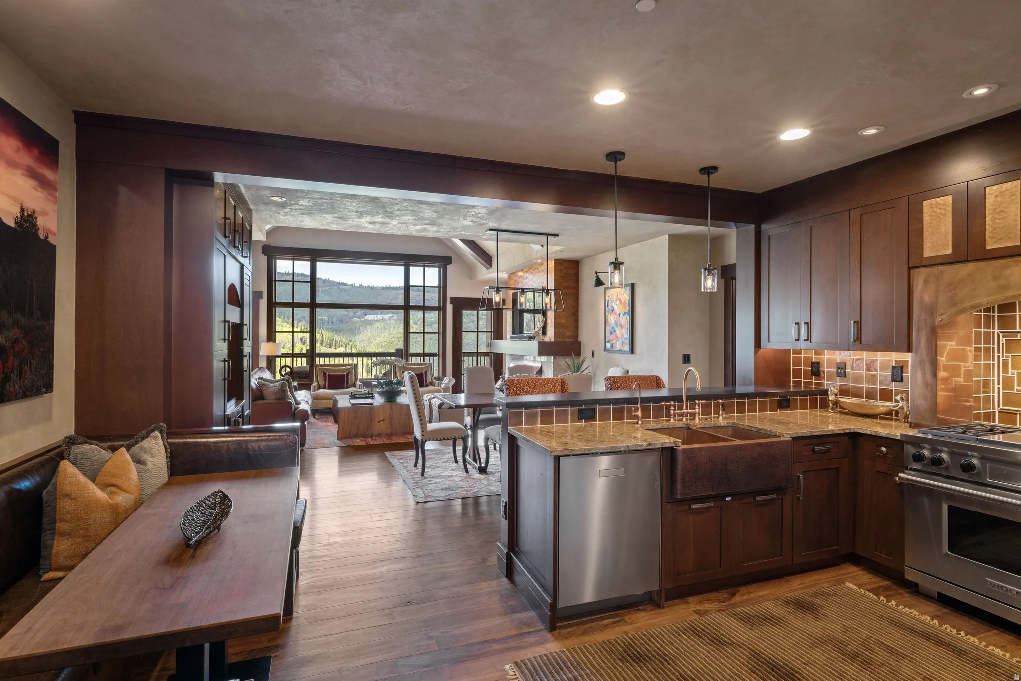 Spacious kitchen featuring wood-finish cabinetry, built-in stainless steel appliances, a copper farmhouse sink, and stone countertops