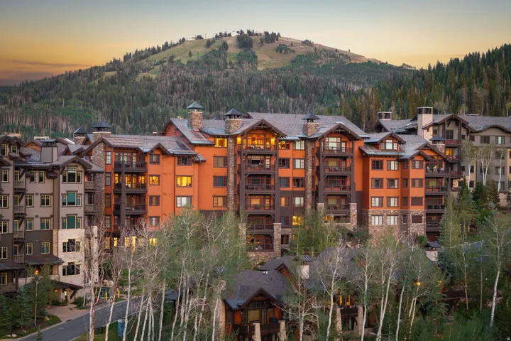 Multi-story building featuring stone and wood-finish exterior, covered balconies, and multiple gabled rooflines