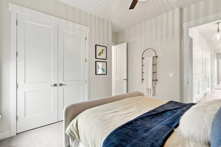 White panel doors with brushed nickel hardware, light neutral wall colors, and a ceiling fan with integrated lighting