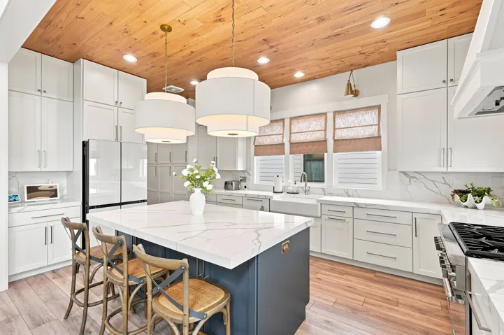Kitchen featuring wood-finish ceiling, white cabinetry, a center island with a white countertop, wood-finish flooring, and a farmhouse sink