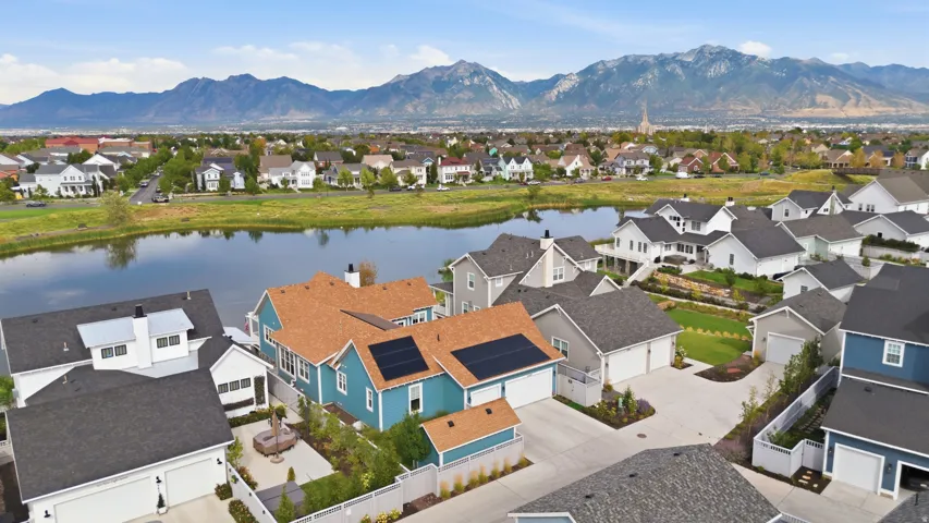 Residential community featuring varied architectural styles, a central pond, and distant mountain scenery