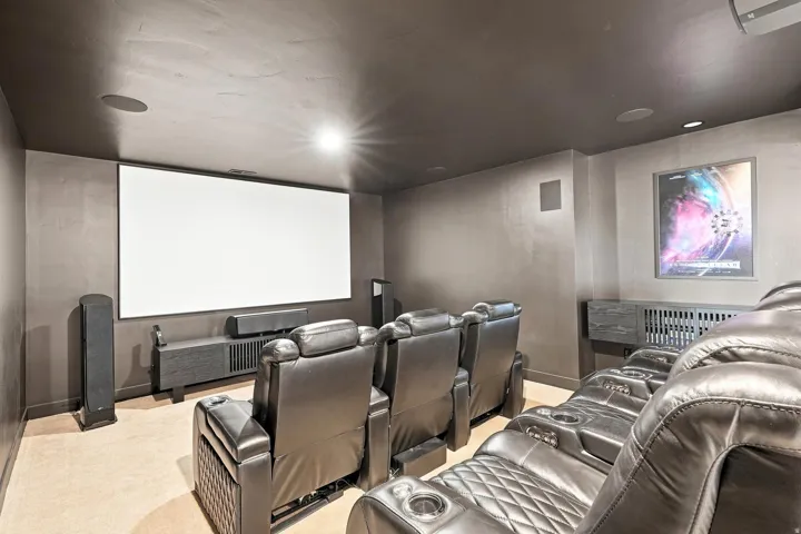 Integrated projection screen, built-in ceiling speakers, recessed lighting, and wall-mounted media console