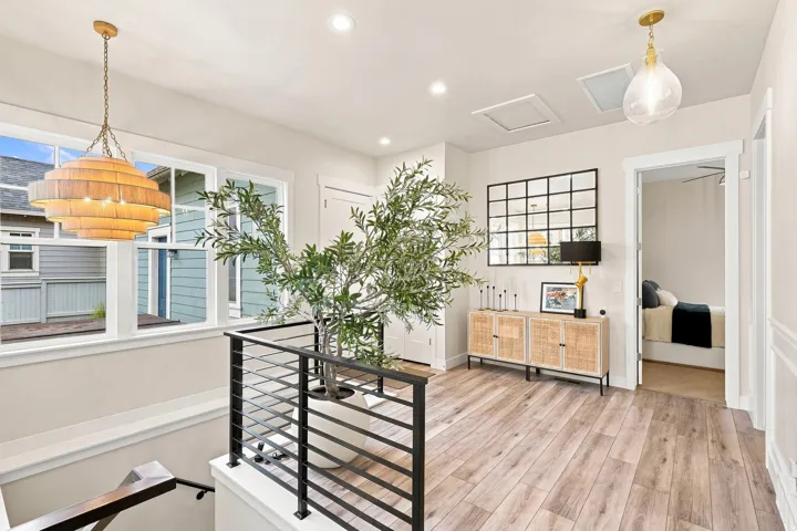 Wood-finish flooring throughout, complemented by a black metal railing