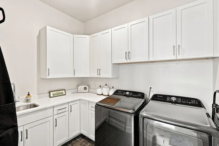 White shaker cabinetry, light-toned countertops, and a stainless steel sink