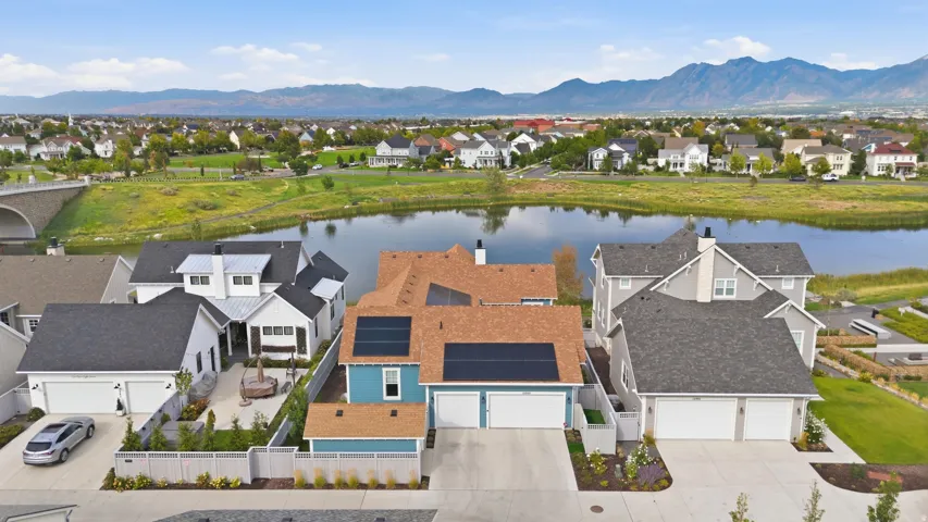 Aerial perspective showcasing a residential community with a large body of water and distant mountains