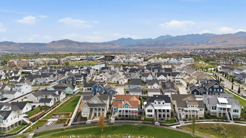 Neighborhood featuring a variety of architectural styles, a community green space, and distant mountain backdrops