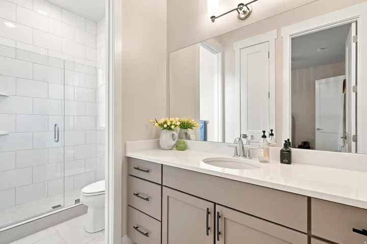 Integrated vanity with a single basin, light-toned countertop, and undermount sink