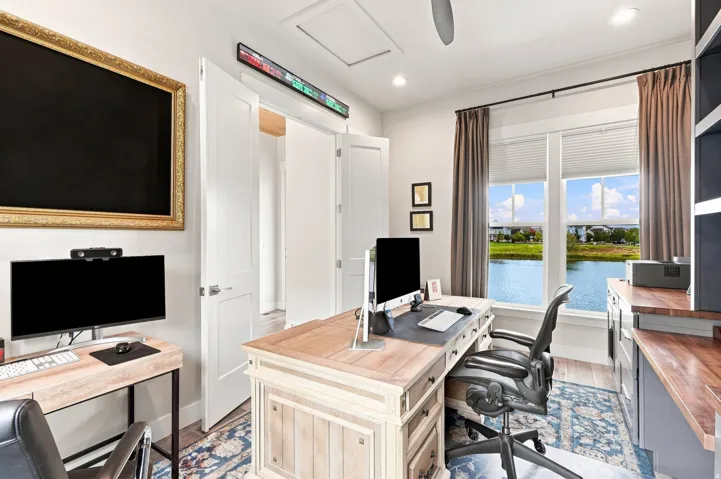 Dual pane windows with custom window treatments, built-in shelving, wood-finish flooring, recessed lighting, and a white ceiling fan