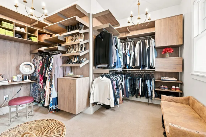 Custom closet system featuring wood-finish cabinetry, integrated shelving, and multiple hanging rods