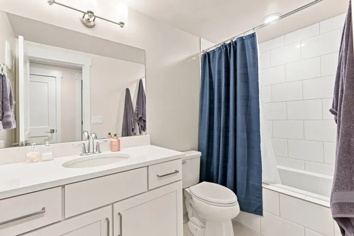 Bathroom featuring a single vanity with an integrated sink, polished chrome faucet, and white cabinetry