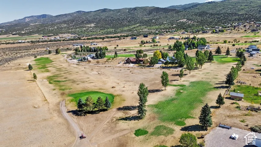Expansive golf course setting featuring  mature trees, and mountain backdrop