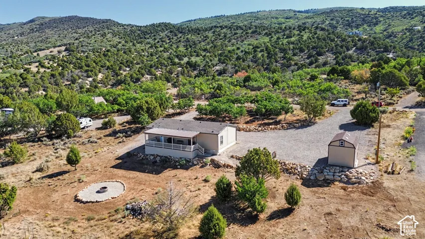 Ariel view of Expansive property with a gravel driveway, covered front porch, and a dedicated storage shed