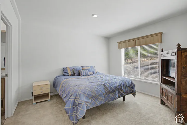 Master bedroom with carpeted flooring, recessed lighting, and a window with blinds and a decorative valance