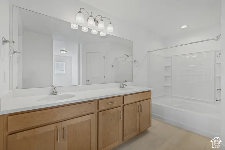 Double vanity with light wood-finish cabinetry and white countertops