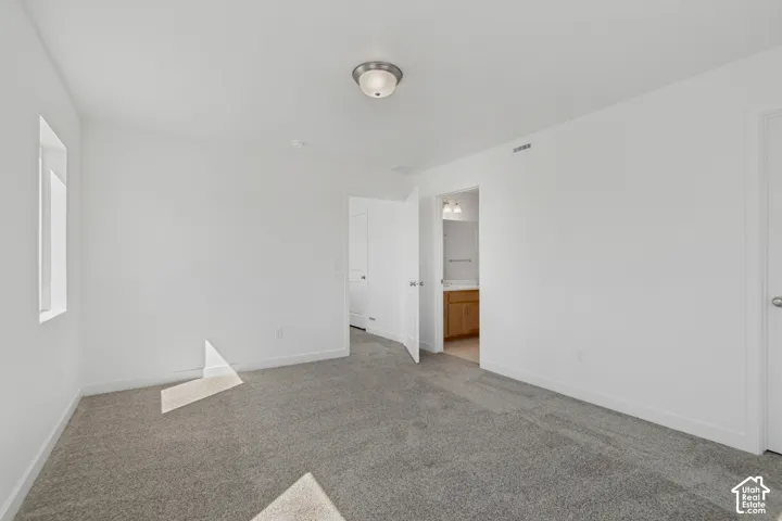Gray carpeting, white painted walls, and a semi-flush ceiling light fixture