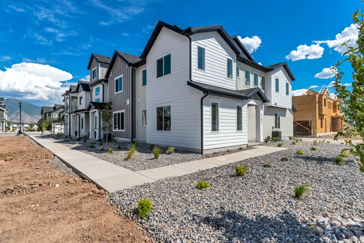 Contemporary exterior with white and gray siding, black trim, and multiple windows