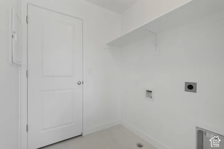 Dedicated laundry area featuring a built-in shelf, neutral wall tones, and wood-finish flooring