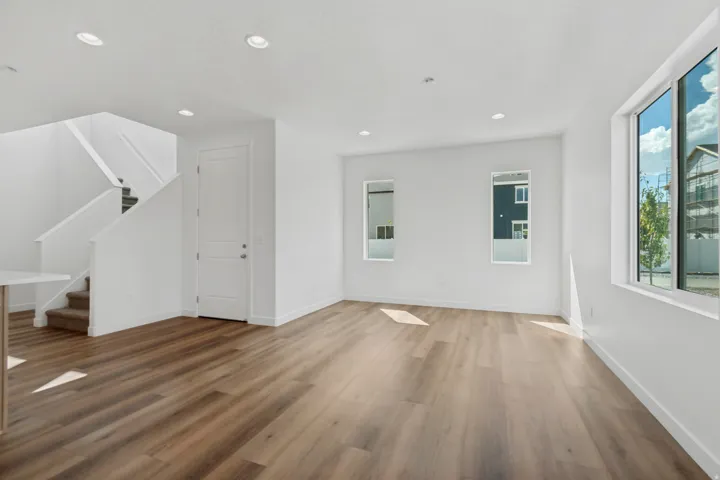 Bright interior with wood-finish flooring, recessed lighting, and white walls