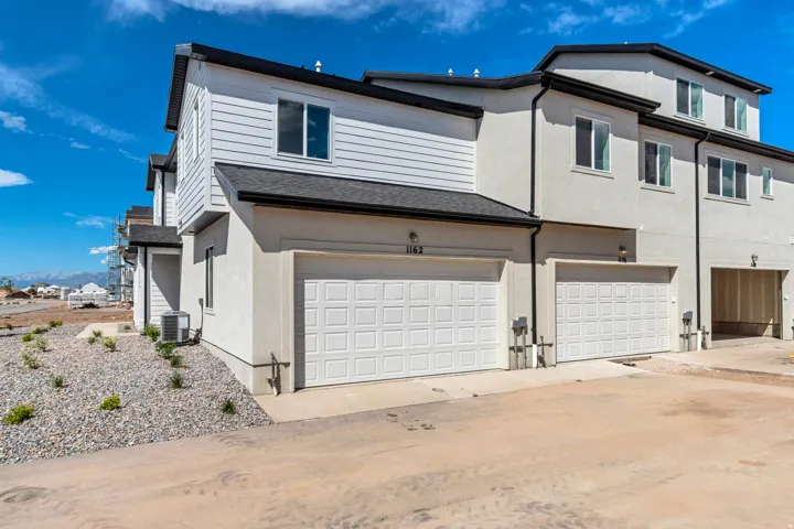 Contemporary townhome exterior featuring white siding and stucco finishes