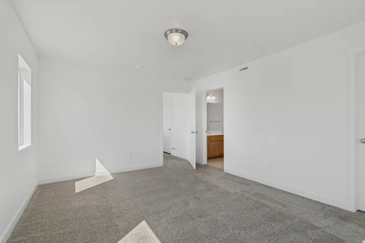 Gray carpeting, white painted walls, and a semi-flush ceiling light fixture