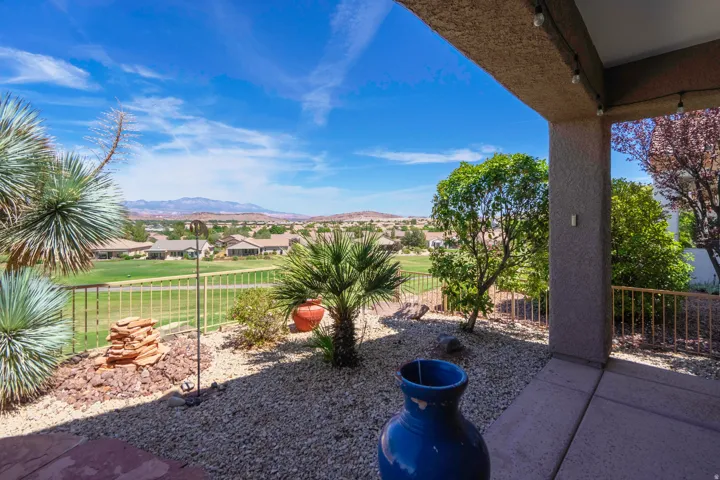 Covered patio with integrated lighting, desert landscaping, and a fenced perimeter