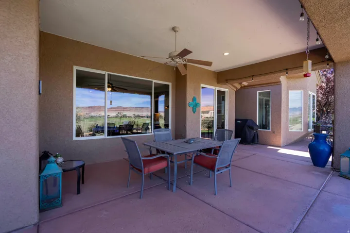 Expansive covered patio with polished concrete flooring, ceiling fan, and recessed lighting