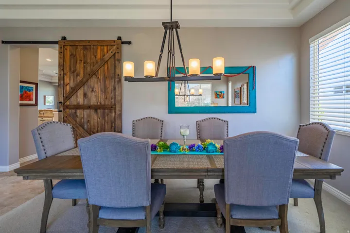 Formal dining area featuring a tray ceiling, recessed lighting, and a modern chandelier