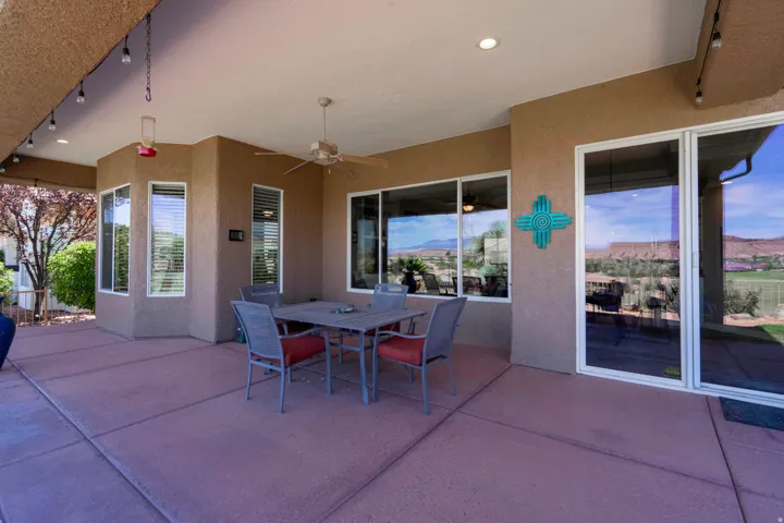 Covered patio featuring recessed lighting, a ceiling fan, multiple windows, and a sliding glass door