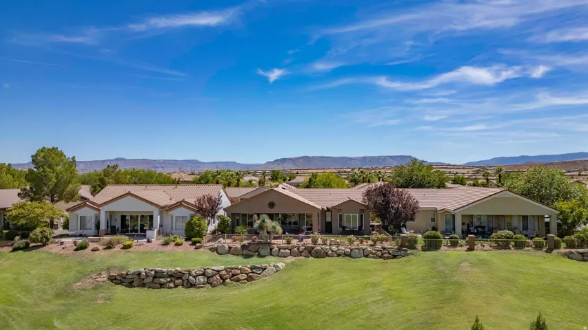 Expansive grounds featuring manicured lawns, mature landscaping, and stone hardscaping elements