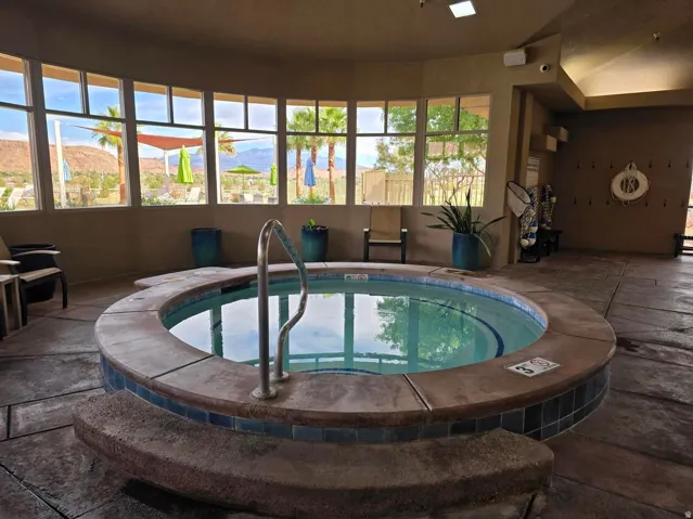 Circular spa with a stone surround, integrated grab rail, and tiled accents