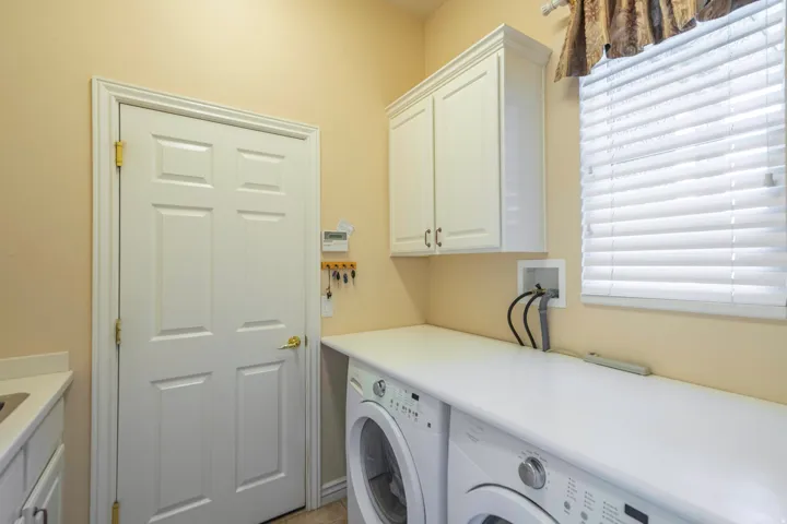 White cabinetry with ample storage, expansive countertop space, and a built-in sink