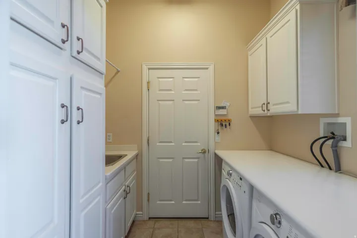 White cabinetry with dark hardware, integrated sink, and white countertop