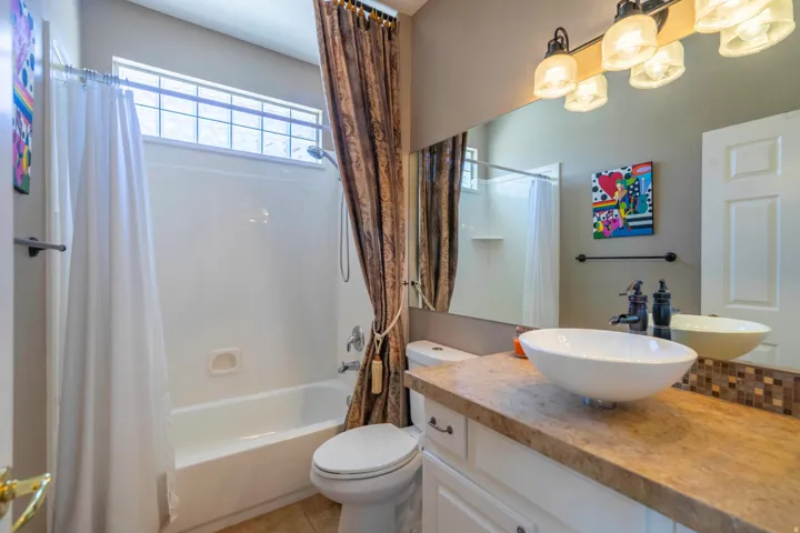 Spa-inspired 2nd bathroom featuring a contemporary vessel sink with wood-finish vanity, quartz countertop, and polished chrome fixtures